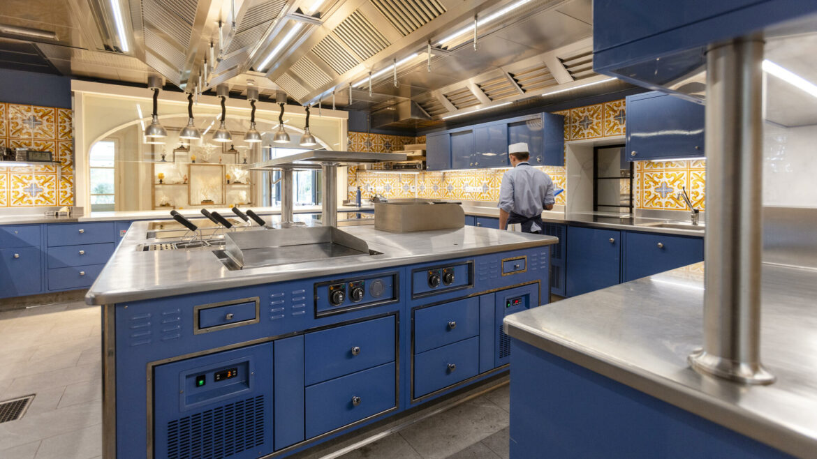 Elegant Molteni kitchen with blue appliances and yellow and blue tiles on the walls